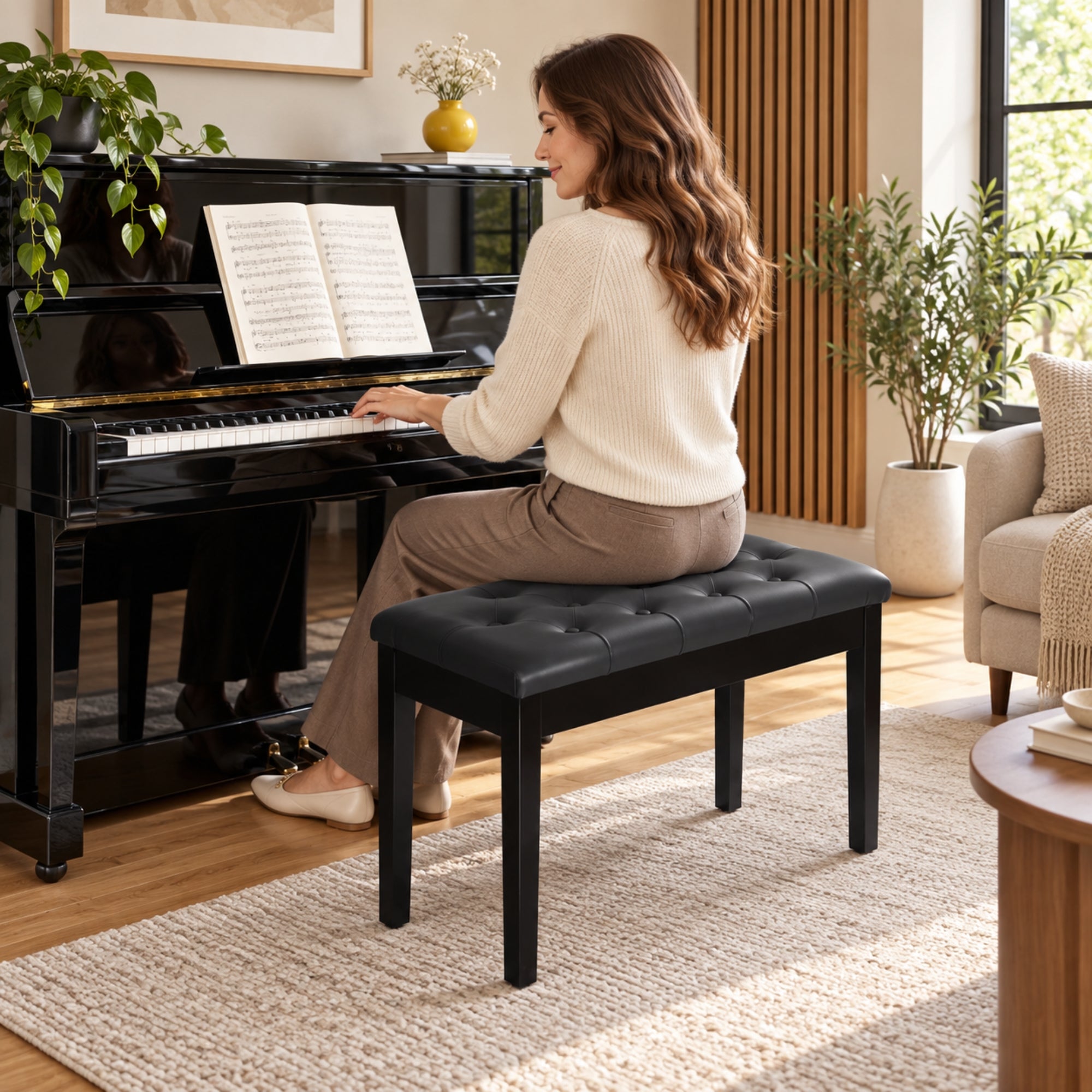 Zwarte pianobank met opbergruimte – klassiek design en zitcomfort met vrouw die piano speelt op zachte kunstleren zitting