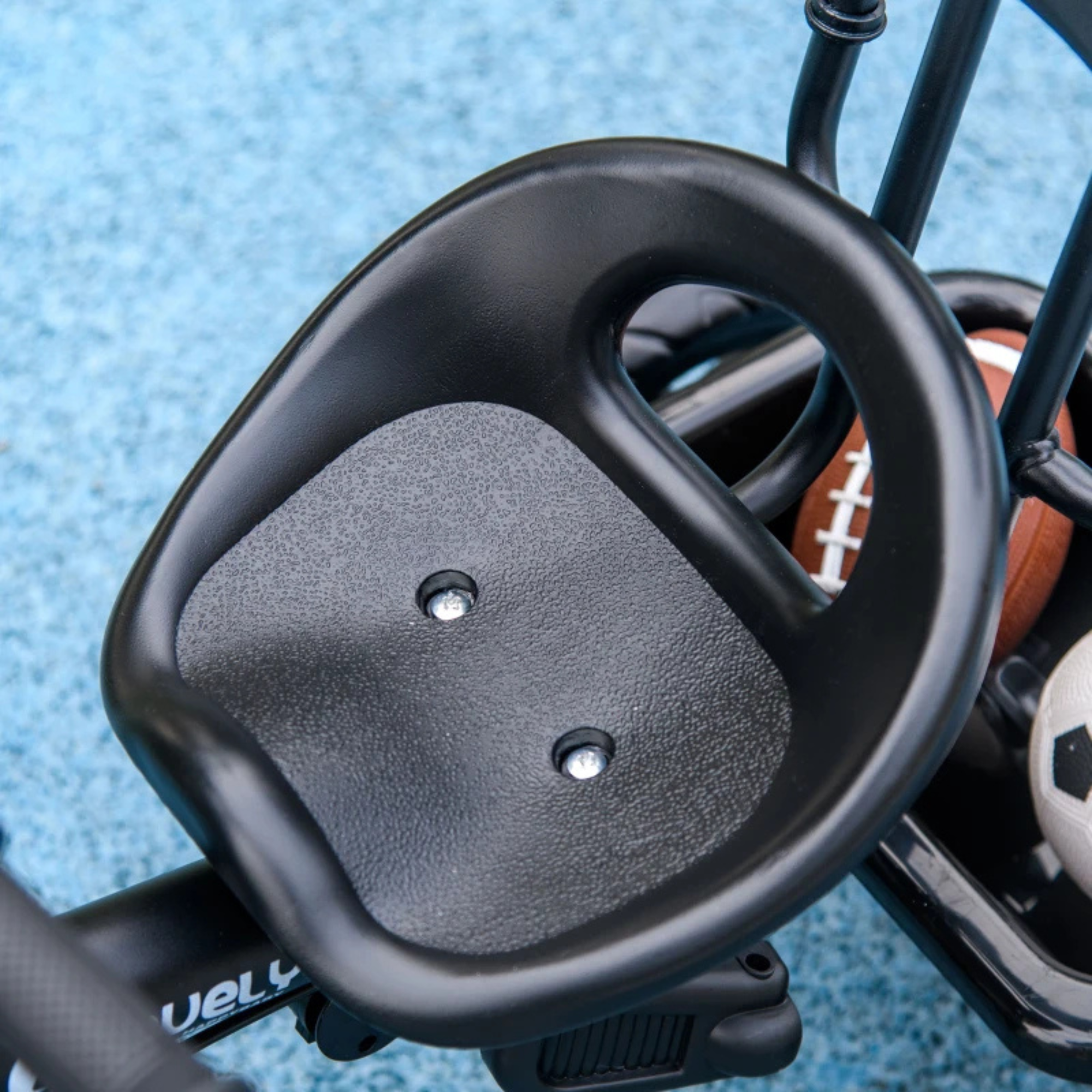 Dichtbij opname van het zwarte zadel van de Driewieler voor kinderen van  1-5 jaar met duwstang, donkerblauw en stevig