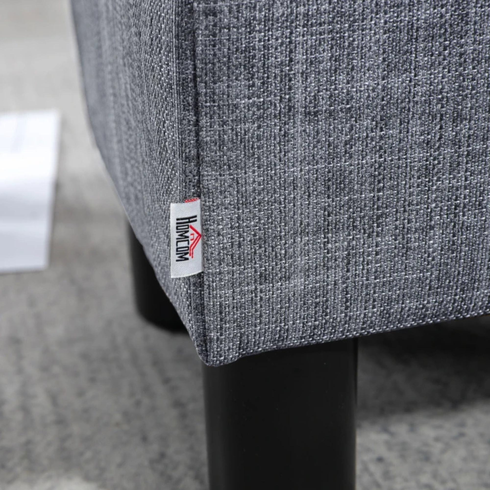 Stijlvolle grijze fauteuil met zwarte poten en wit label